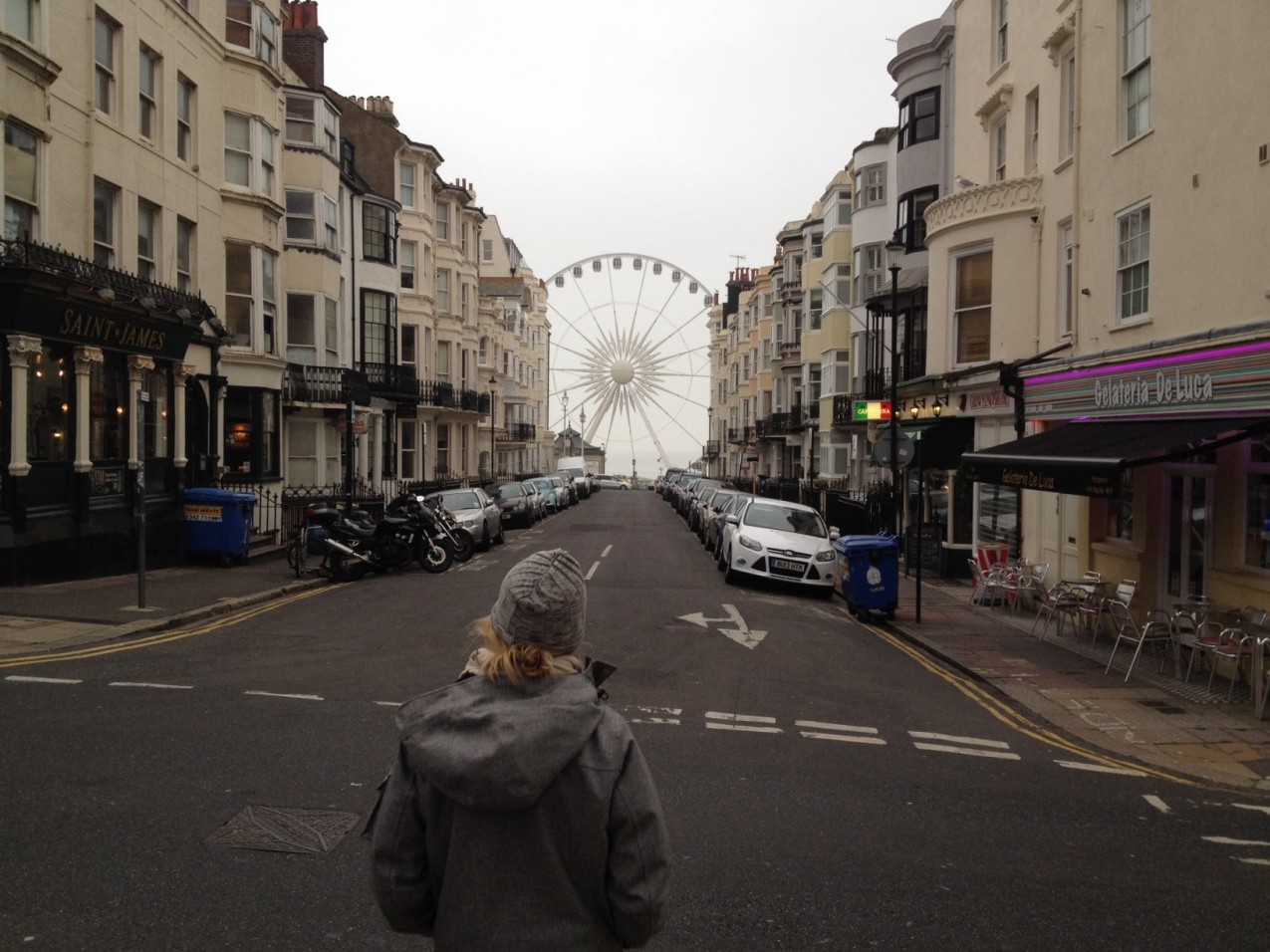 Person kigger ned af tom engelsk gade med pariserhjul for enden.